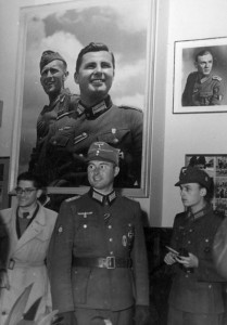 Леон Дегрель під час прес-конференції у Берліні, на фоні власних фото з-під Черкас...